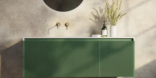 Bathroom vanity with green cabinet, white countertop, and decorative elements.